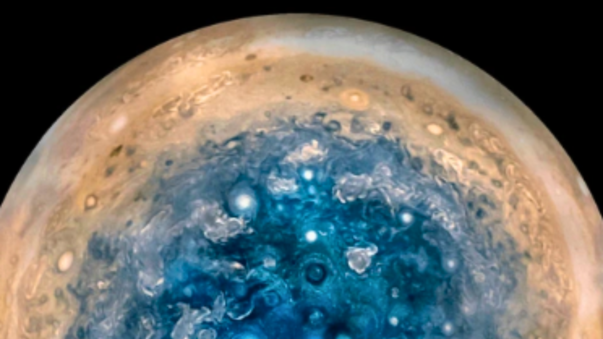 Close-up infrared view of Jupiter’s North Pole, revealing a cluster of massive, swirling cyclones in shades of blue.