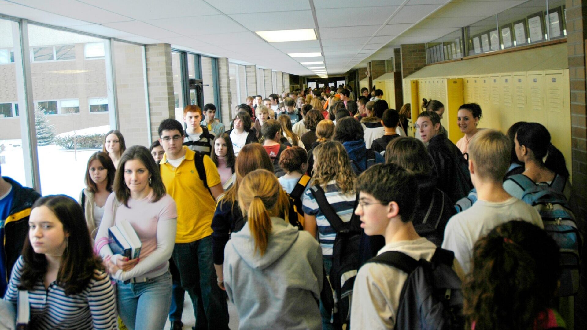 Students walking through crowded high school hallways between classes.