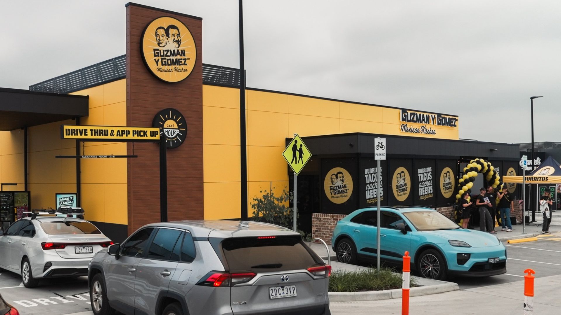 Guzman y Gomez Mexican Kitchen restaurant exterior with drive-thru and customers outside.