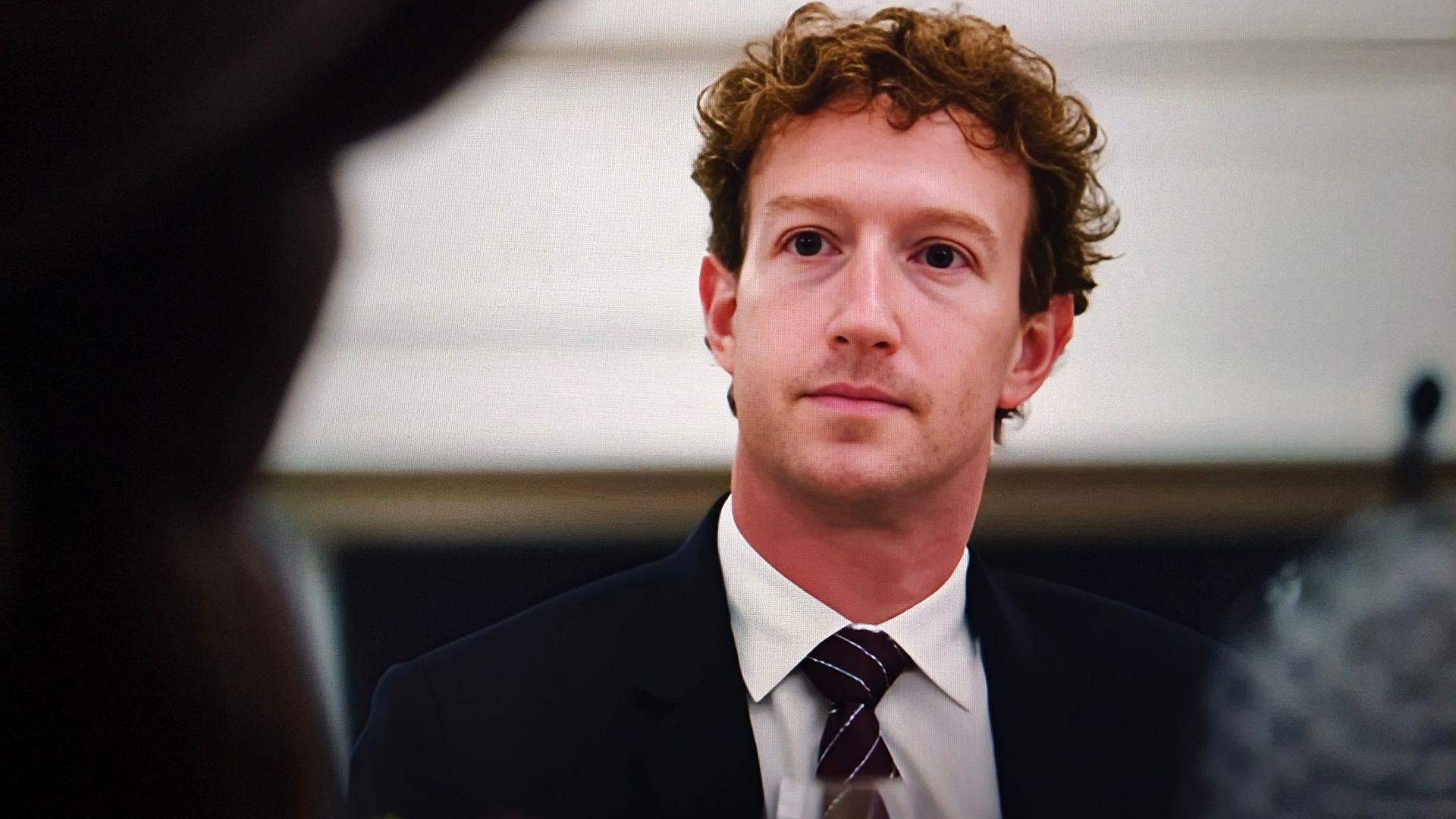 Mark Zuckerberg in a suit, possibly attending a meeting or conference.