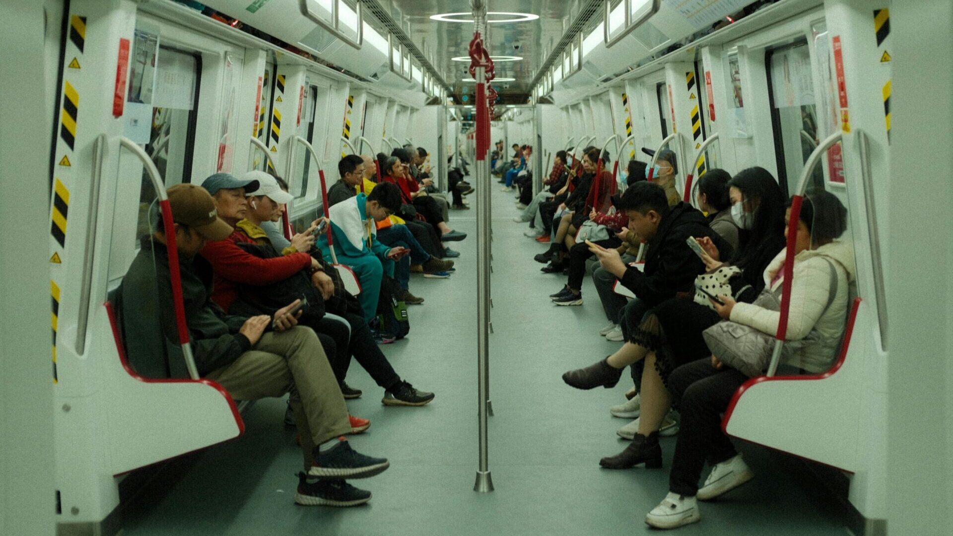 Passengers seated inside a subway car during a public transit commute.