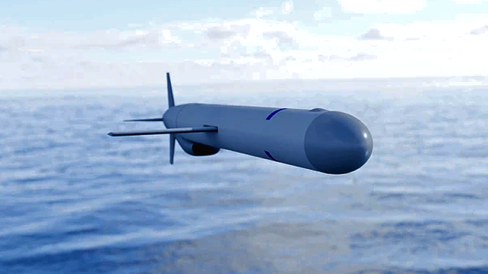 A 3D digital render of a sleek, dark grey Tomahawk Cruise Missile with its wings extended, flying low over a vast, slightly choppy blue ocean under a bright, clear sky.