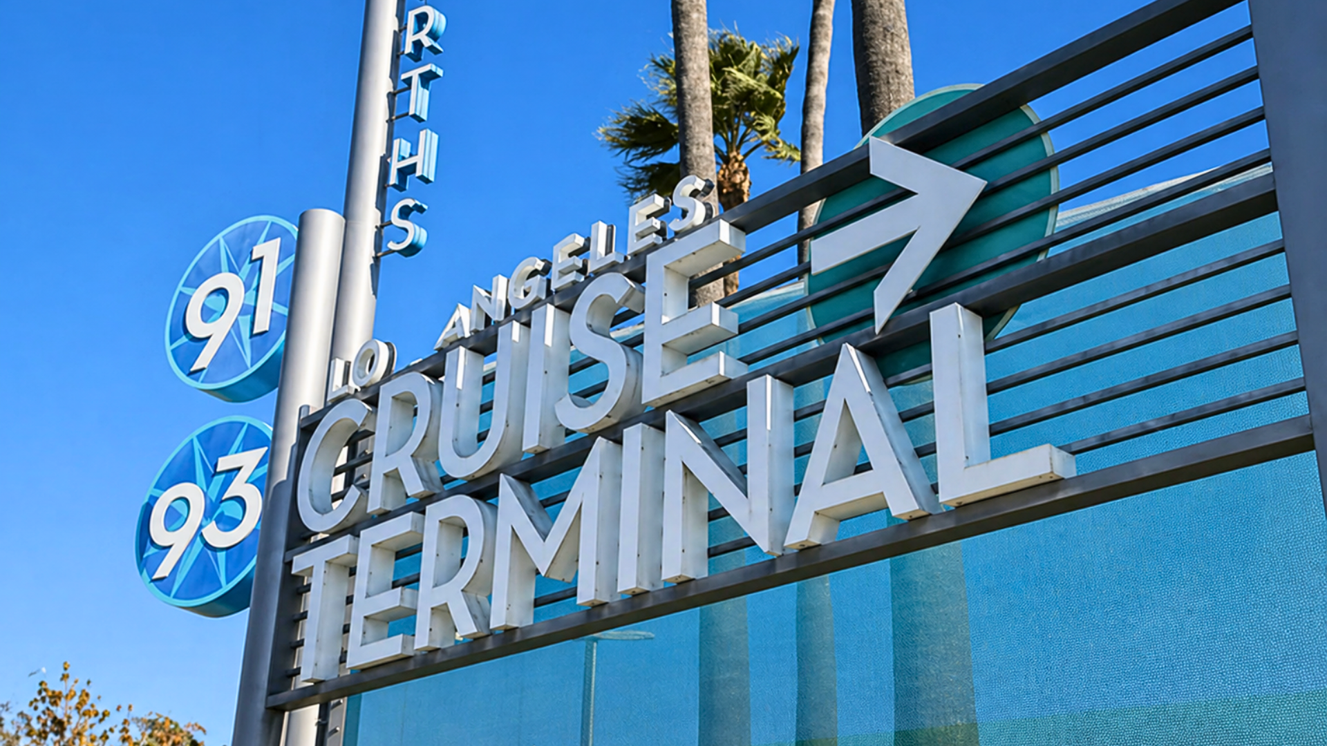 A street-level shot of a modern blue-and-white directional sign with the text 