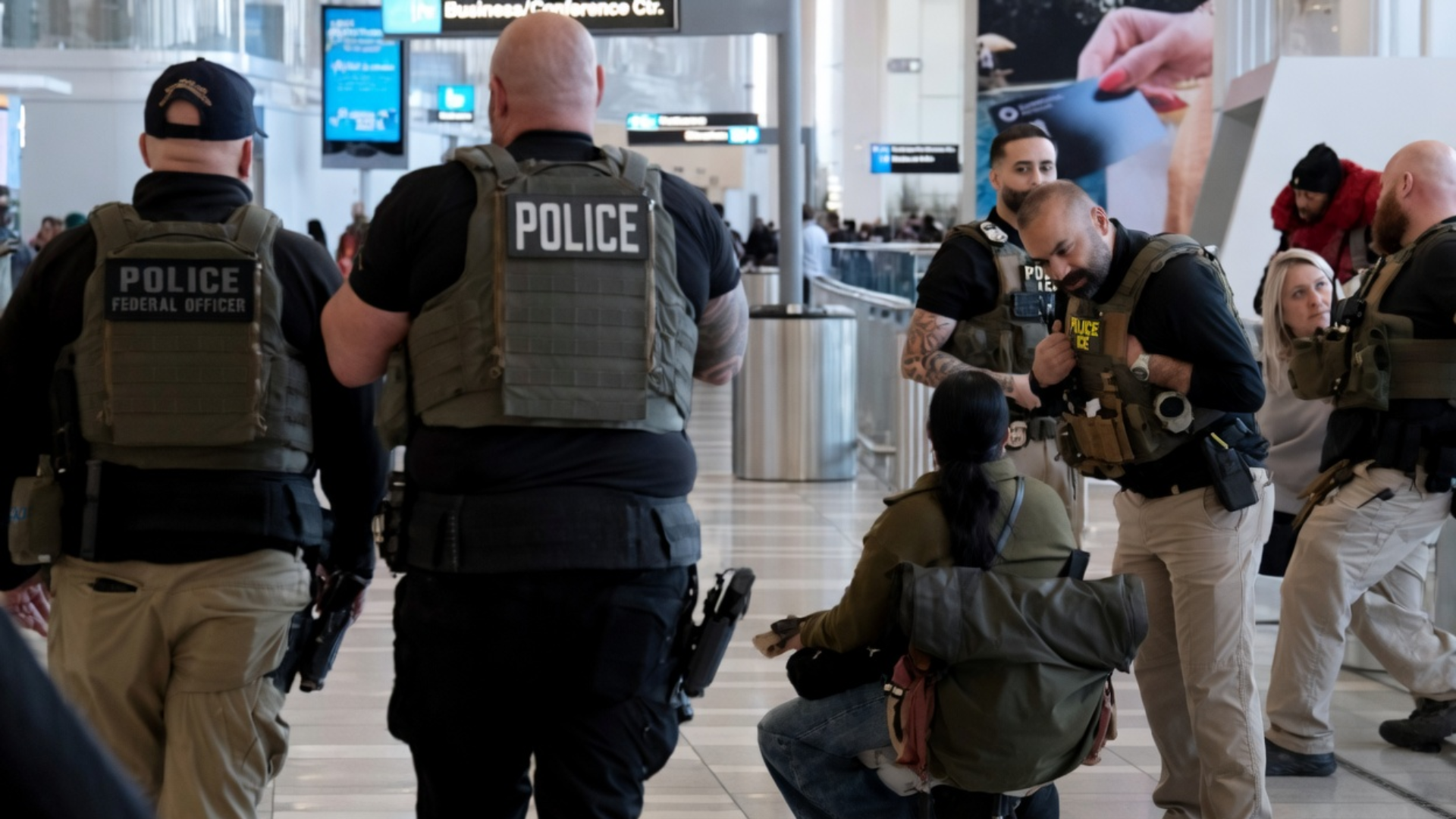 A view from behind of four police officers in tactical vests.