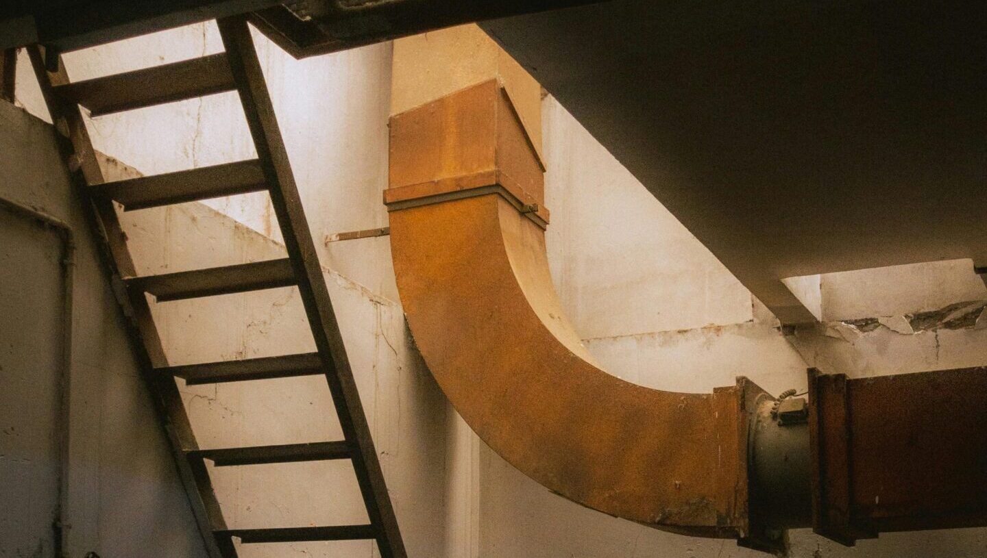 Interior stairwell with metal steps and railings in industrial building.