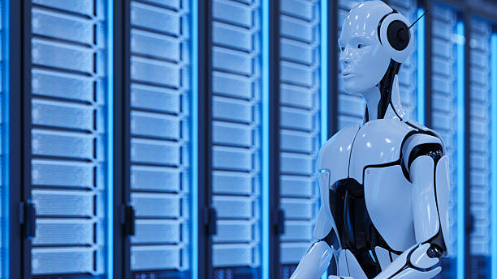 A sleek white humanoid robot standing in a data center aisle.