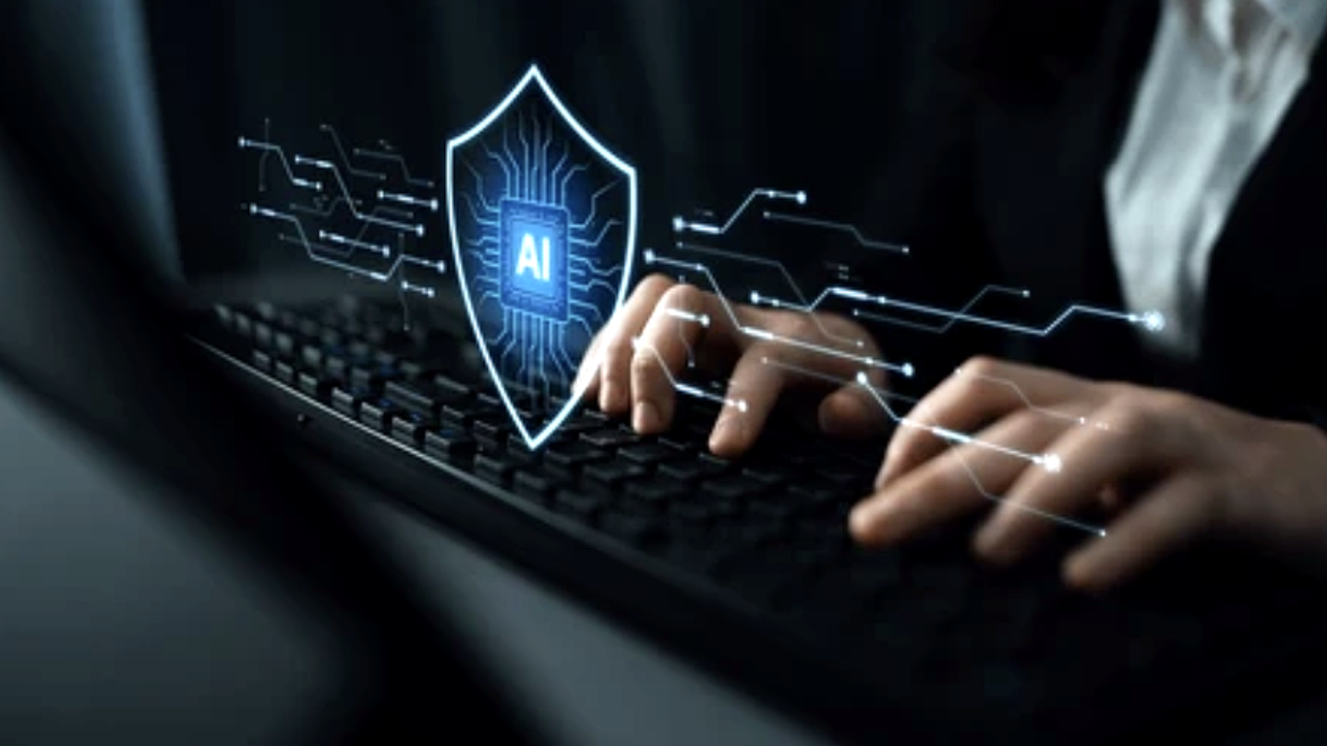 A close-up of a person's hands typing on a black keyboard; a glowing digital shield icon with a microchip center and the text "AI" is superimposed over the keyboard, with blue light trails suggesting a high-tech security interface.