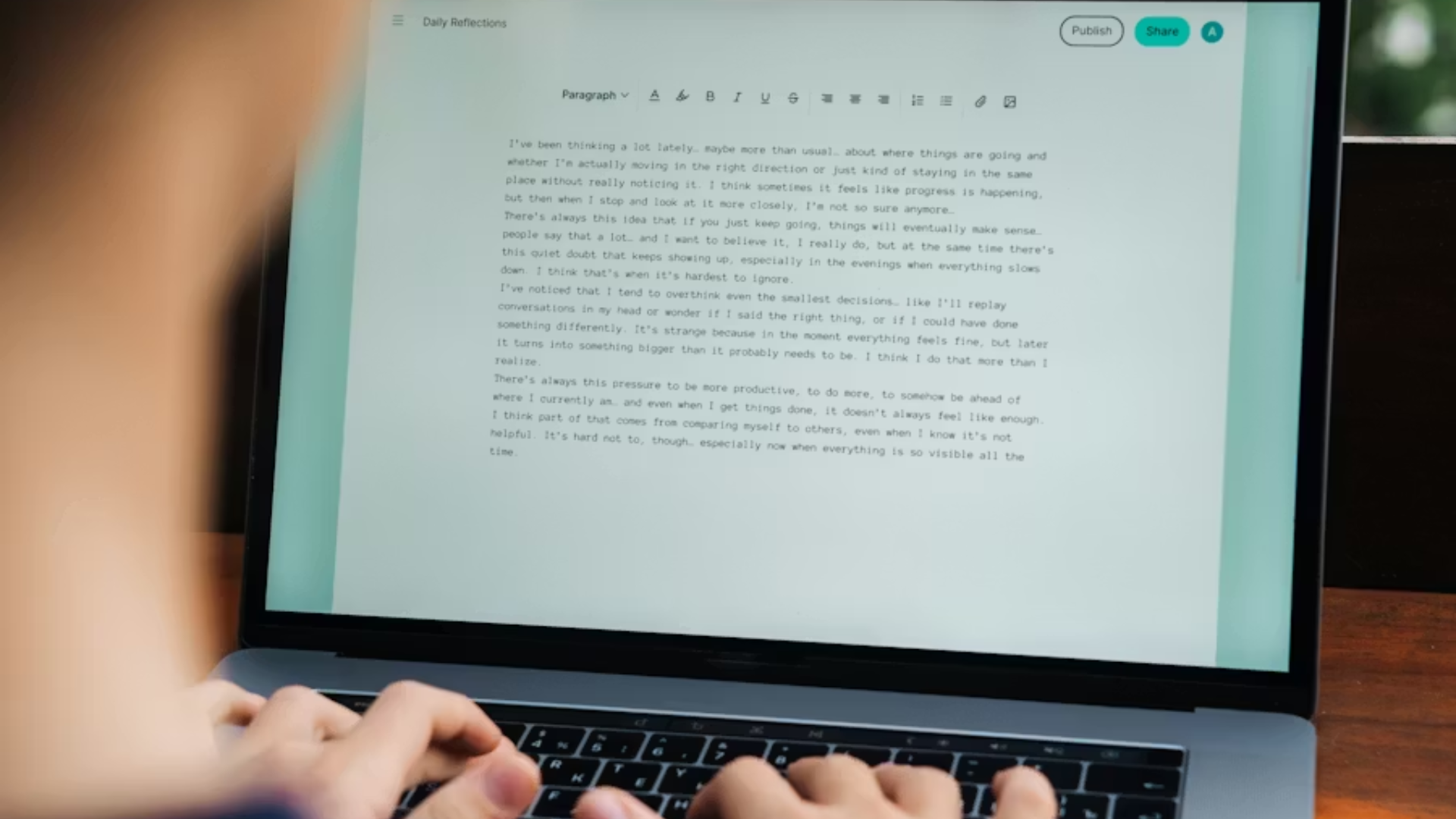 A low-angle shot of a person's hands typing on a laptop keyboard, with the screen displaying a text document suggesting personal journaling or record-keeping.