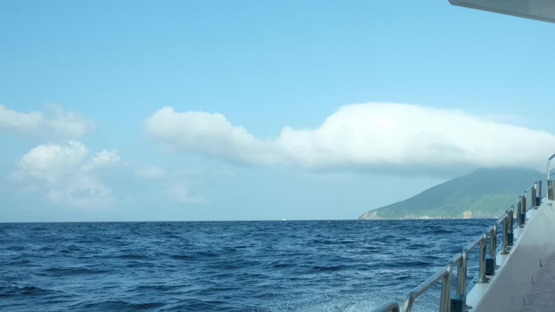 A scenic view from the deck of a boat looking out across the deep blue waters of the South China Sea.