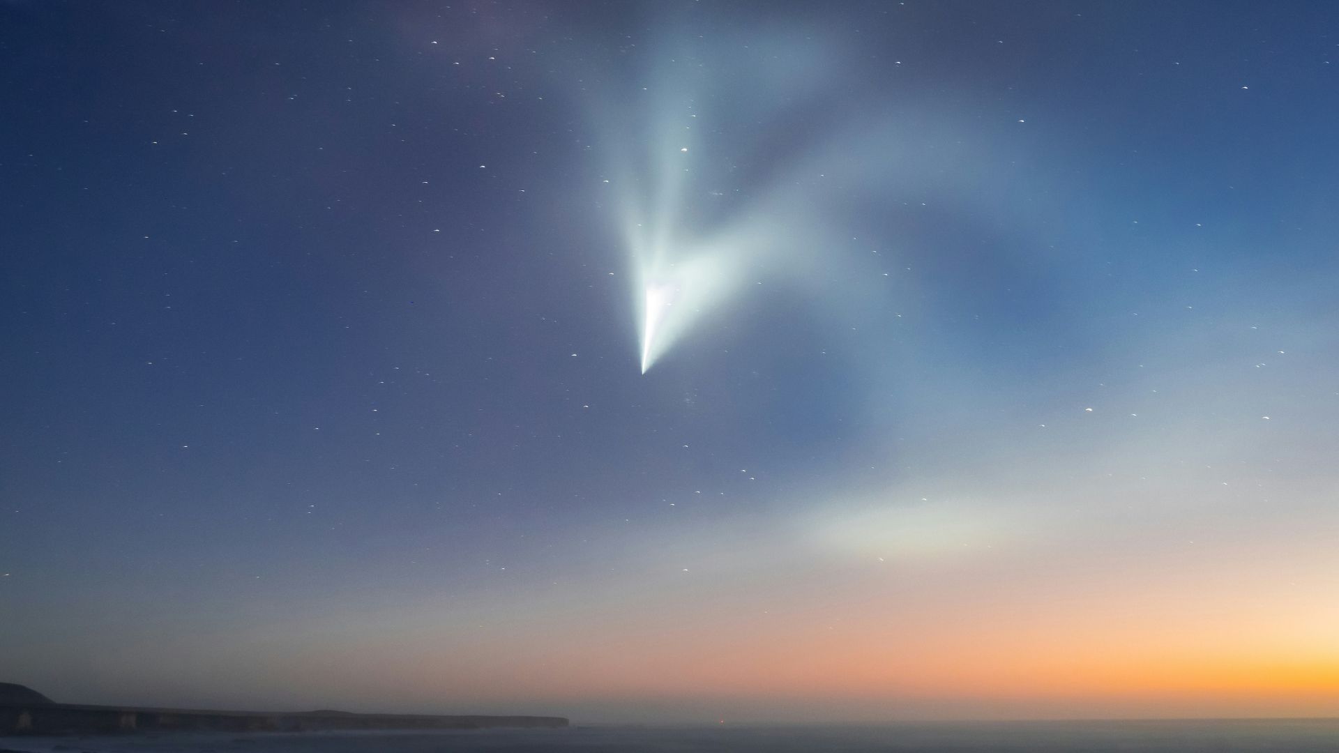 A comet up in the sky making a turn around in space.