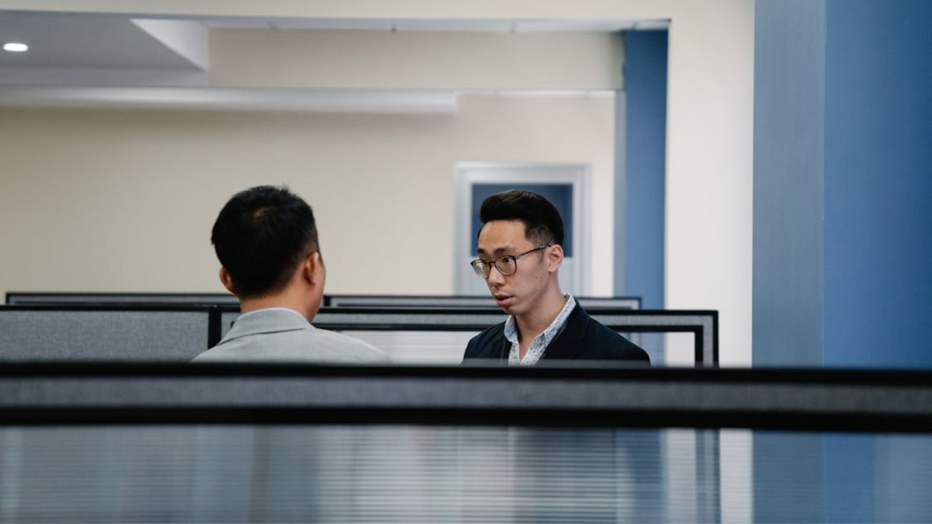 Two employees in an office having a conversation.