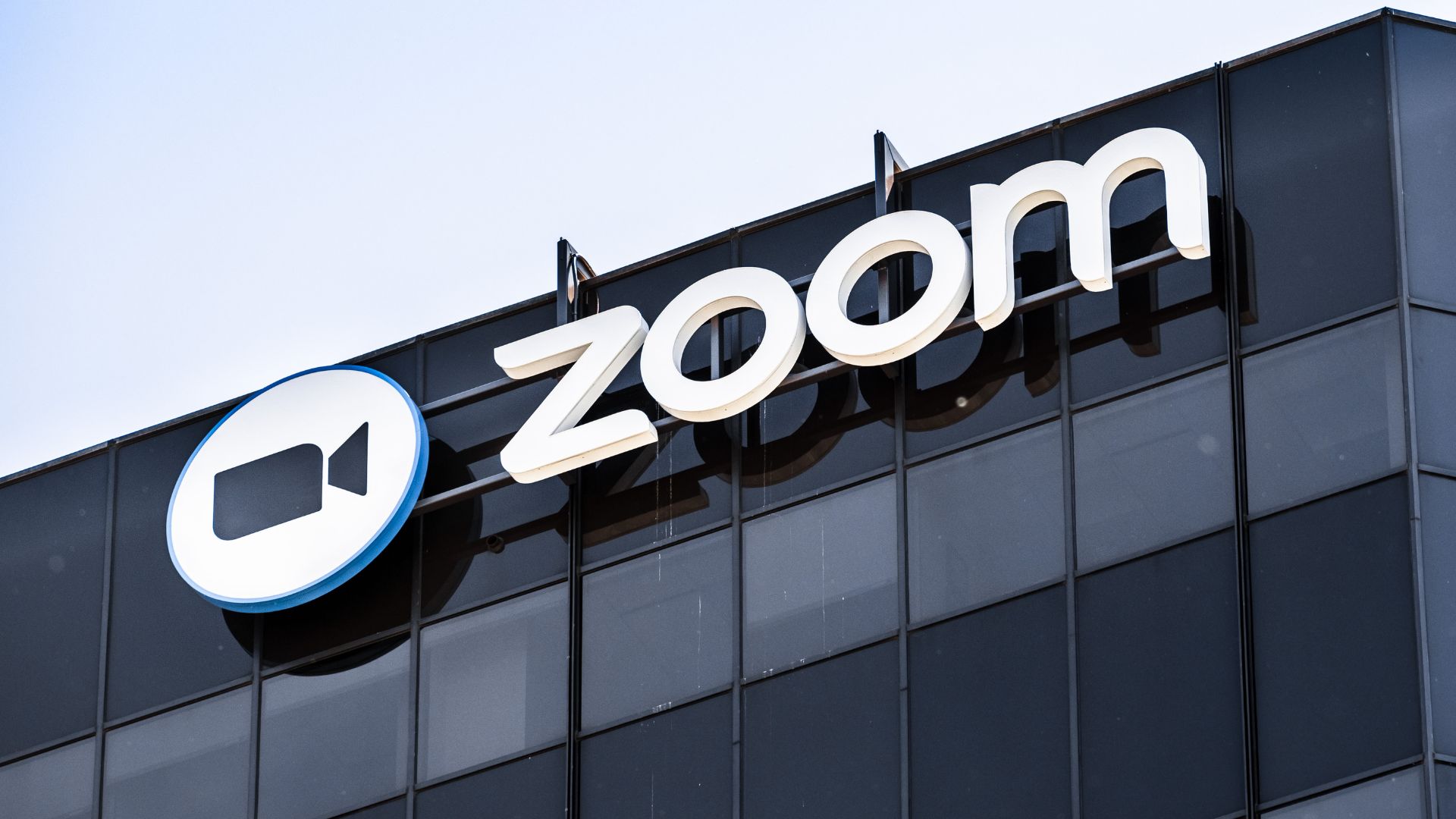 Signage of Zoom on a modern glass building.