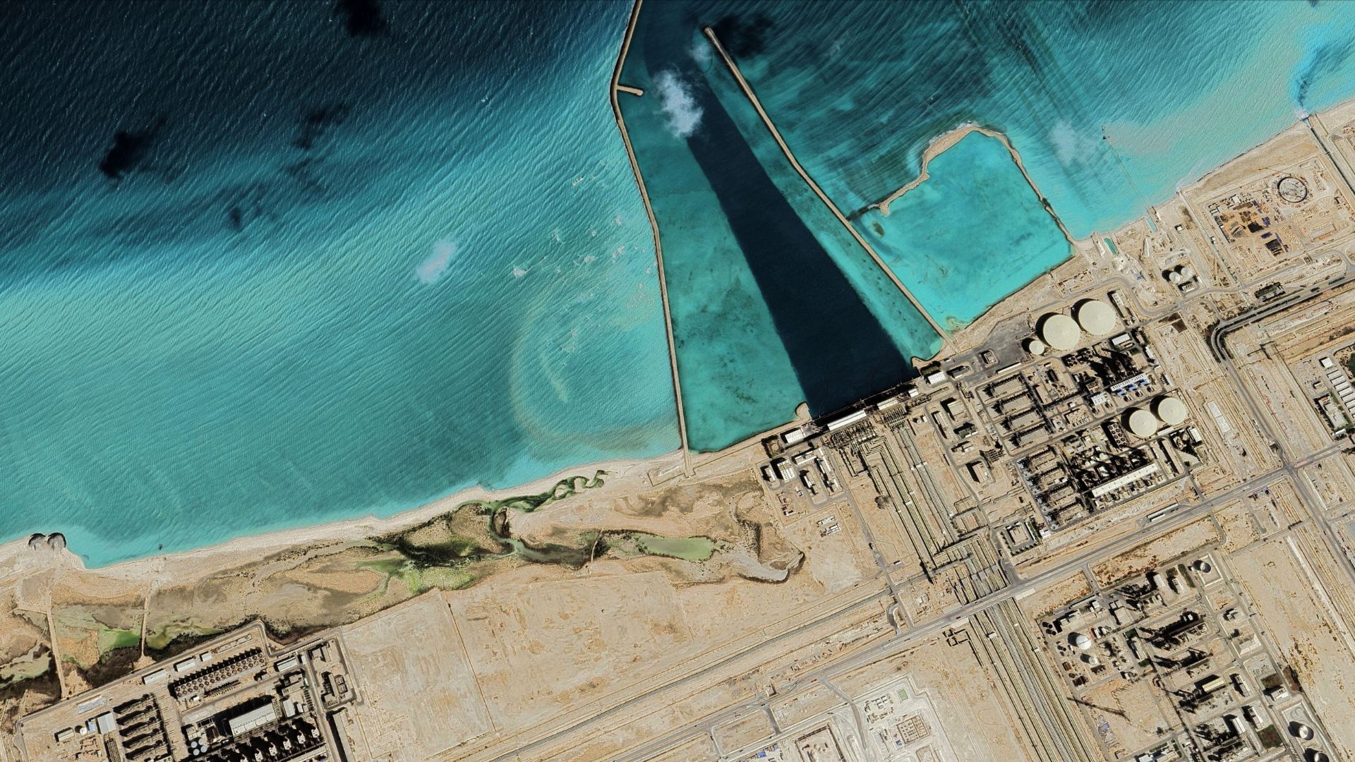satellite view of Ras Laffan industrial facility and LNG terminal pier Qatar.