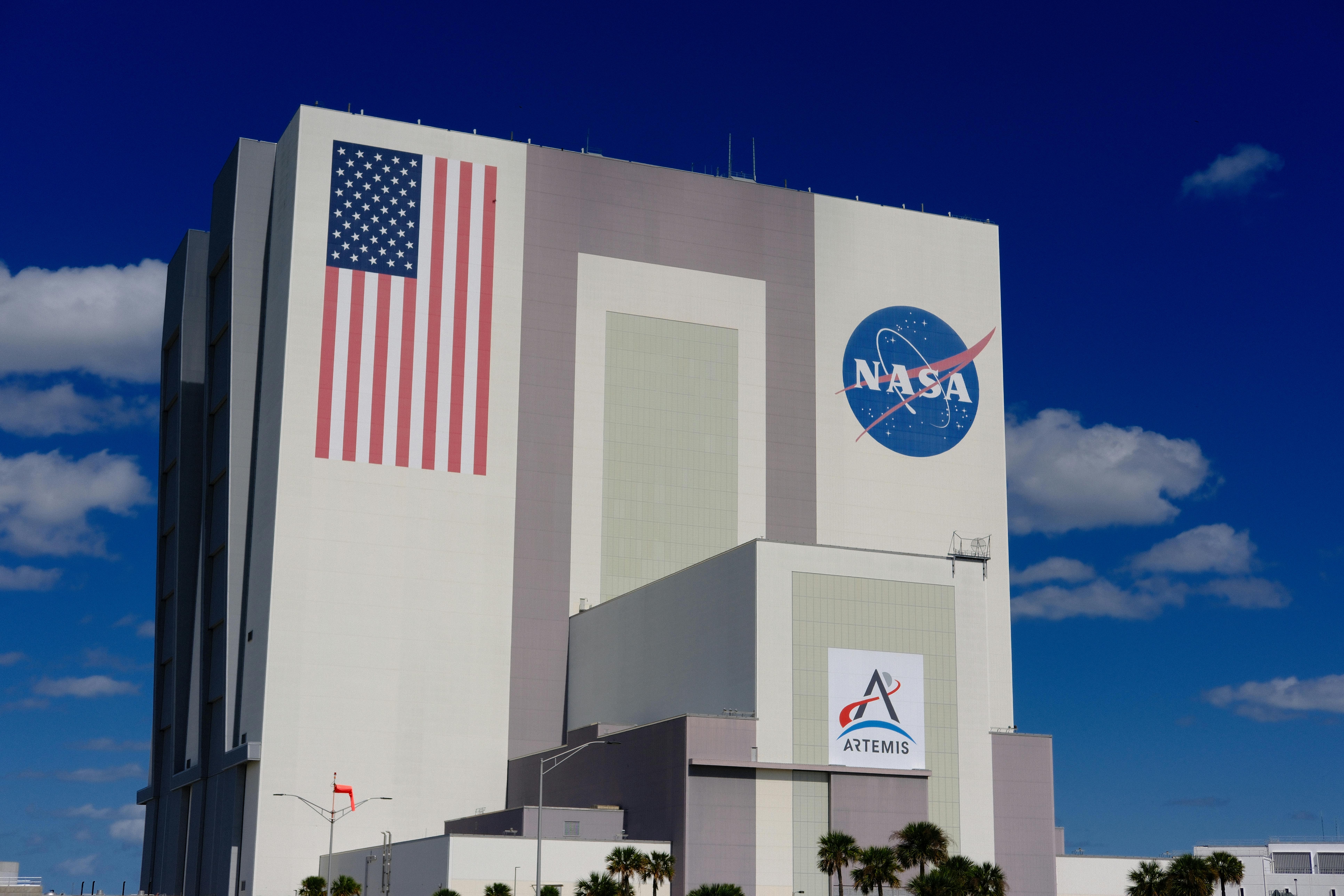 NASA building with American flag and NASA logo displayed on exterior under blue sky.