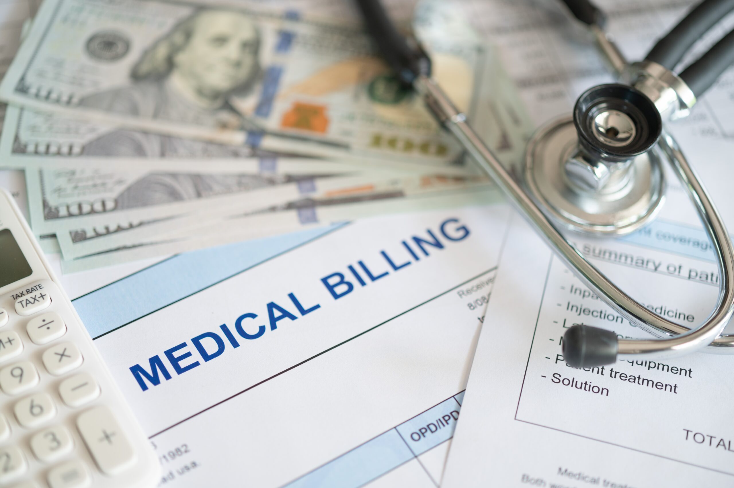 Medical billing documents with cash, calculator, and stethoscope.