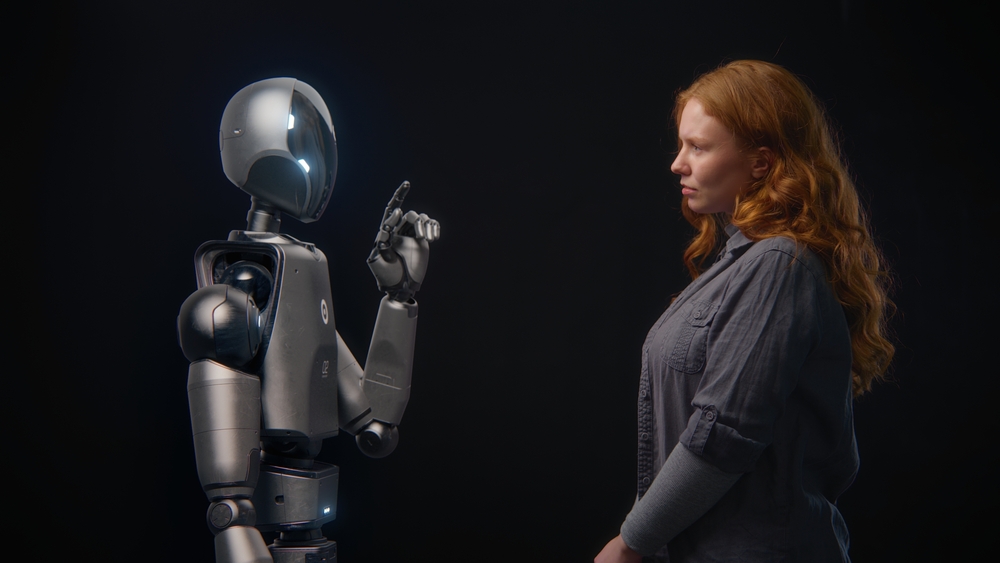 Woman watching a robot in front of her.