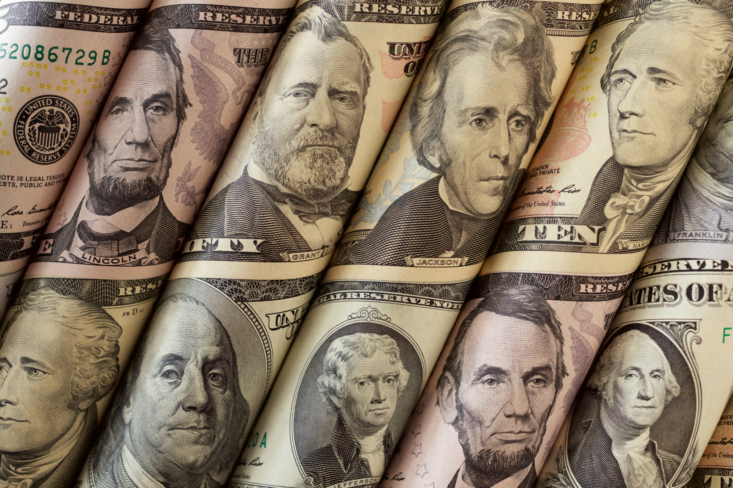 Close-up of U.S. dollar bills showing portraits of presidents.