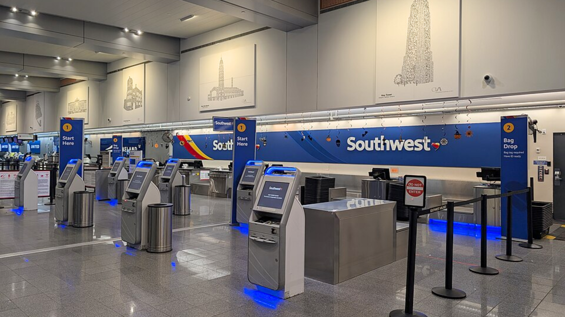 An empty Southwest Airlines airport check-in area featuring several self-service kiosks and bag drop counters.