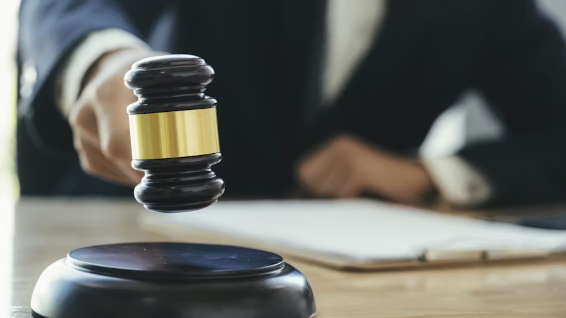 Judge’s gavel striking a sound block during a legal proceeding.