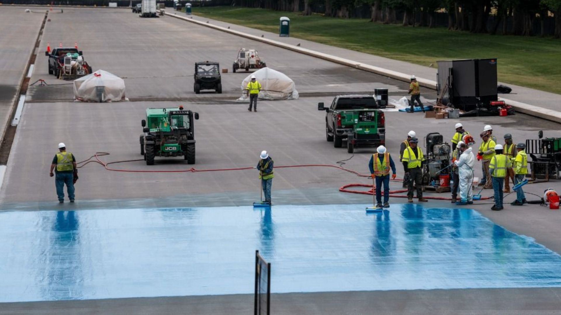 Construction crews repaint sections of the Reflecting Pool blue during controversial federal renovation project.