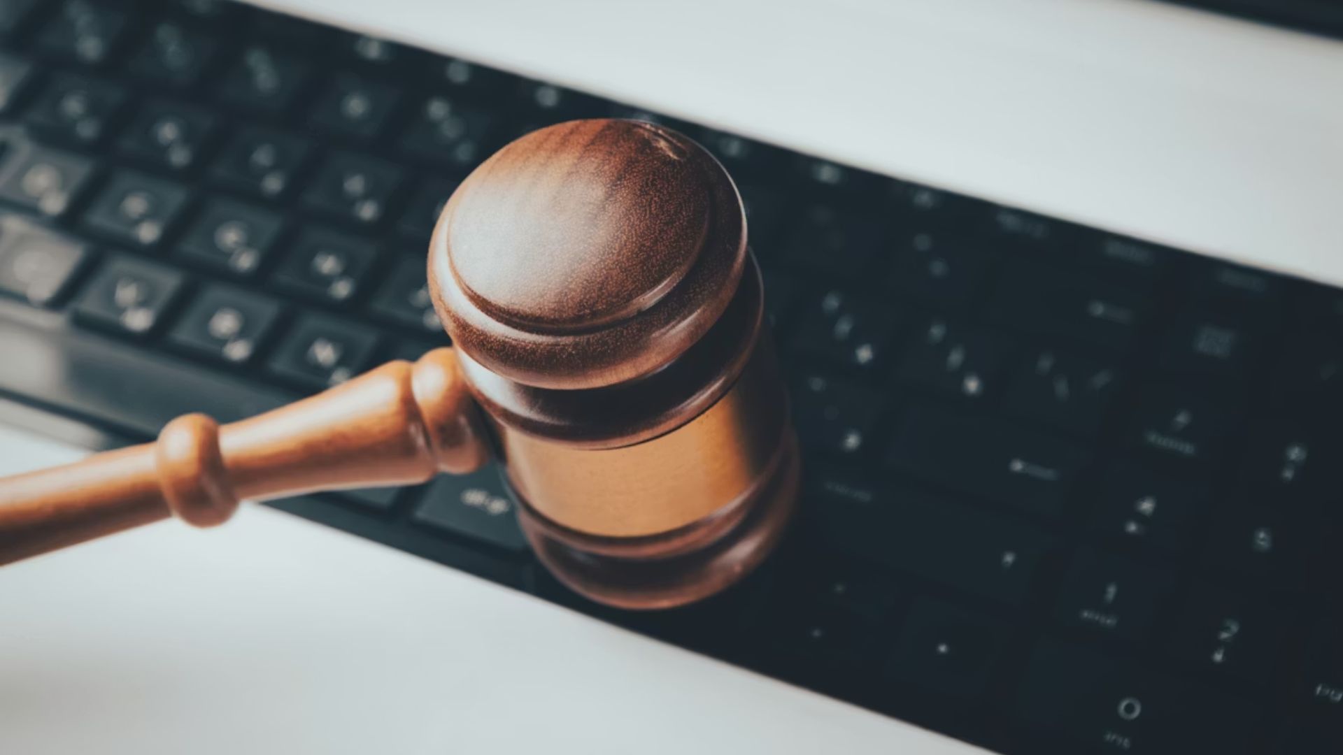 Wooden gavel resting across a keyboard.