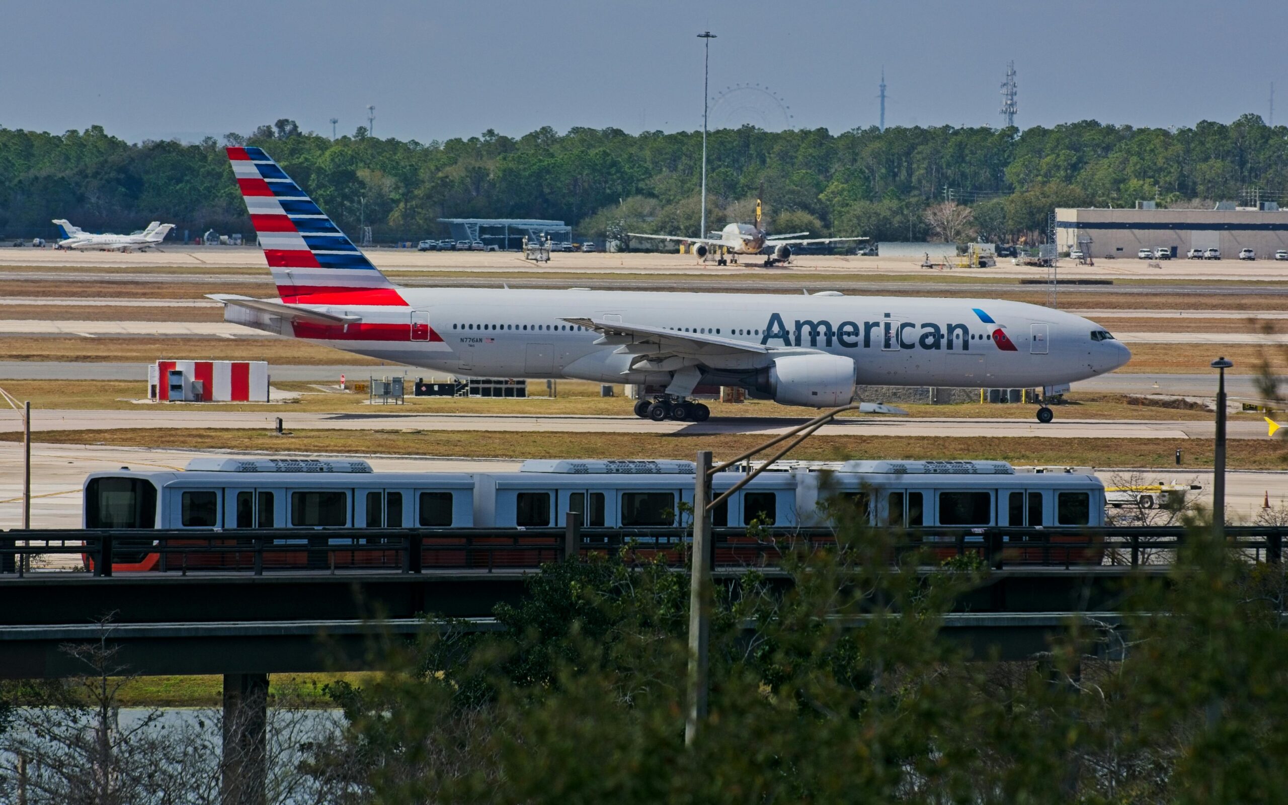 American Airlines plane taxiing on an airport runway.