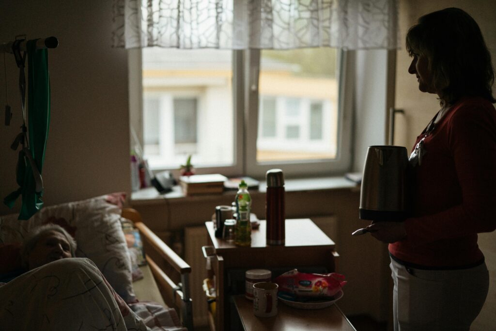Home healthcare worker assists an elderly patient receiving care in a residential setting.