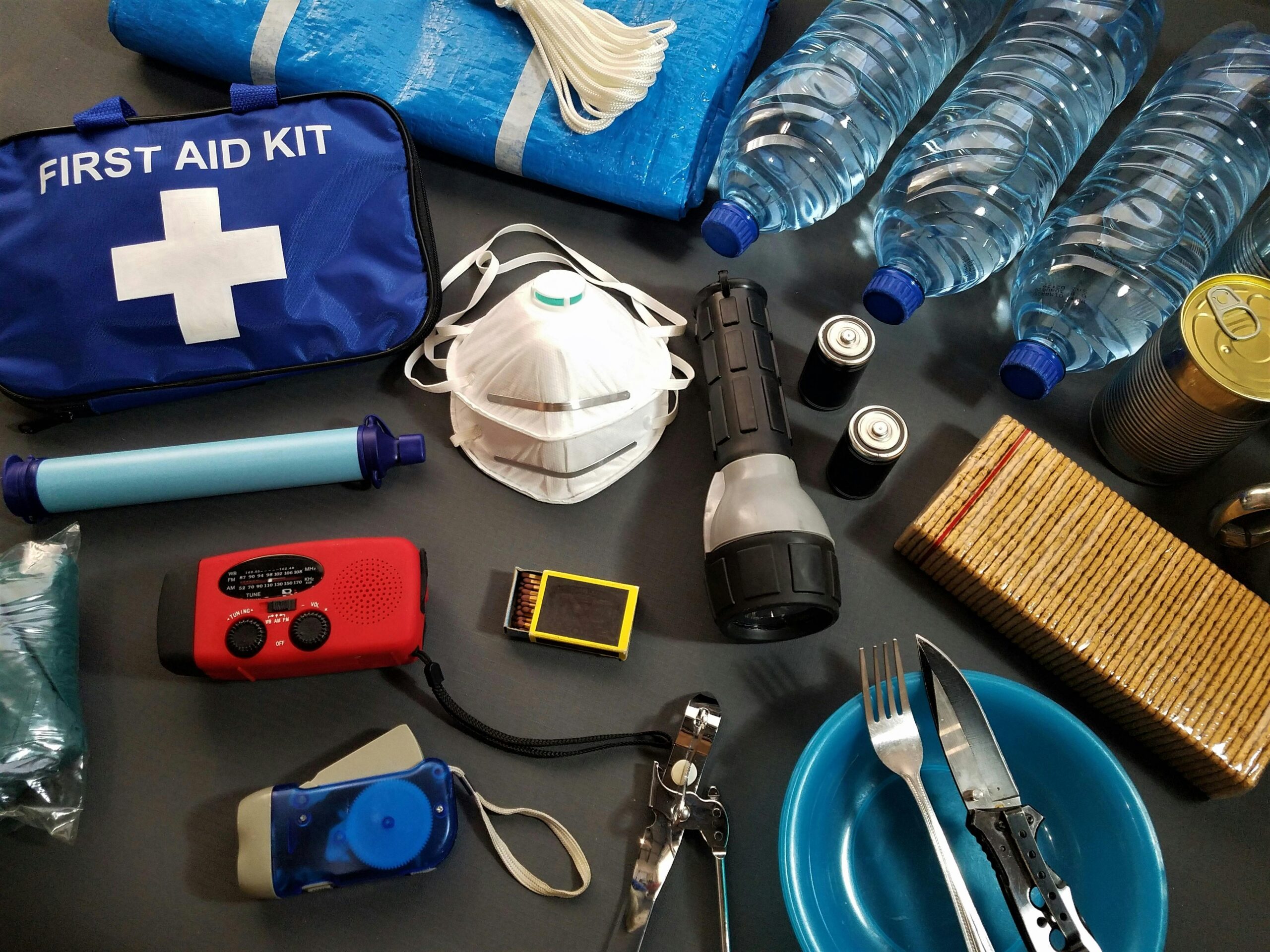 Emergency preparedness kit with water, first aid supplies, flashlight, radio, and food items recommended for earthquake disasters