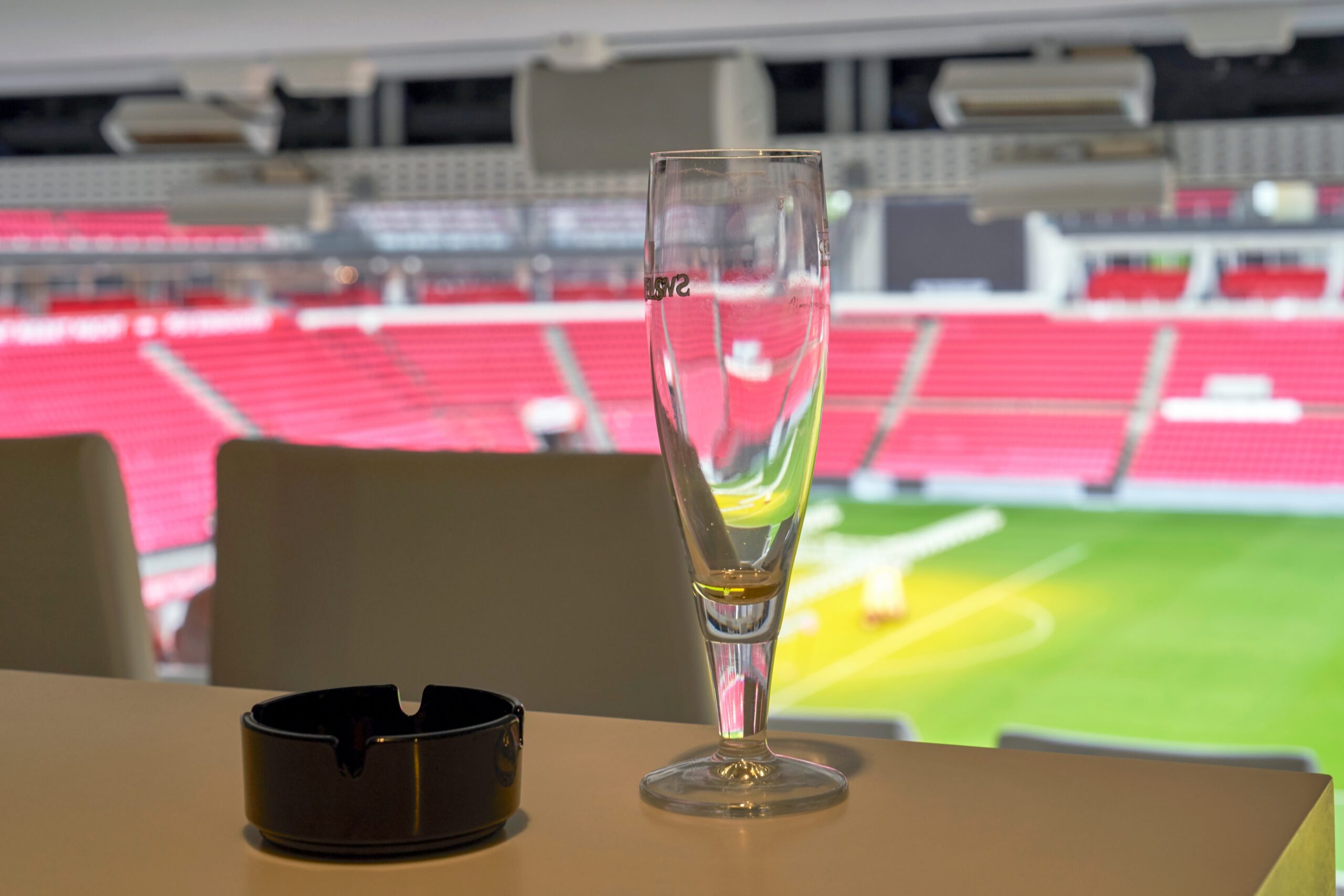 Luxury stadium suite overlooking a soccer field with premium seating and hospitality space.