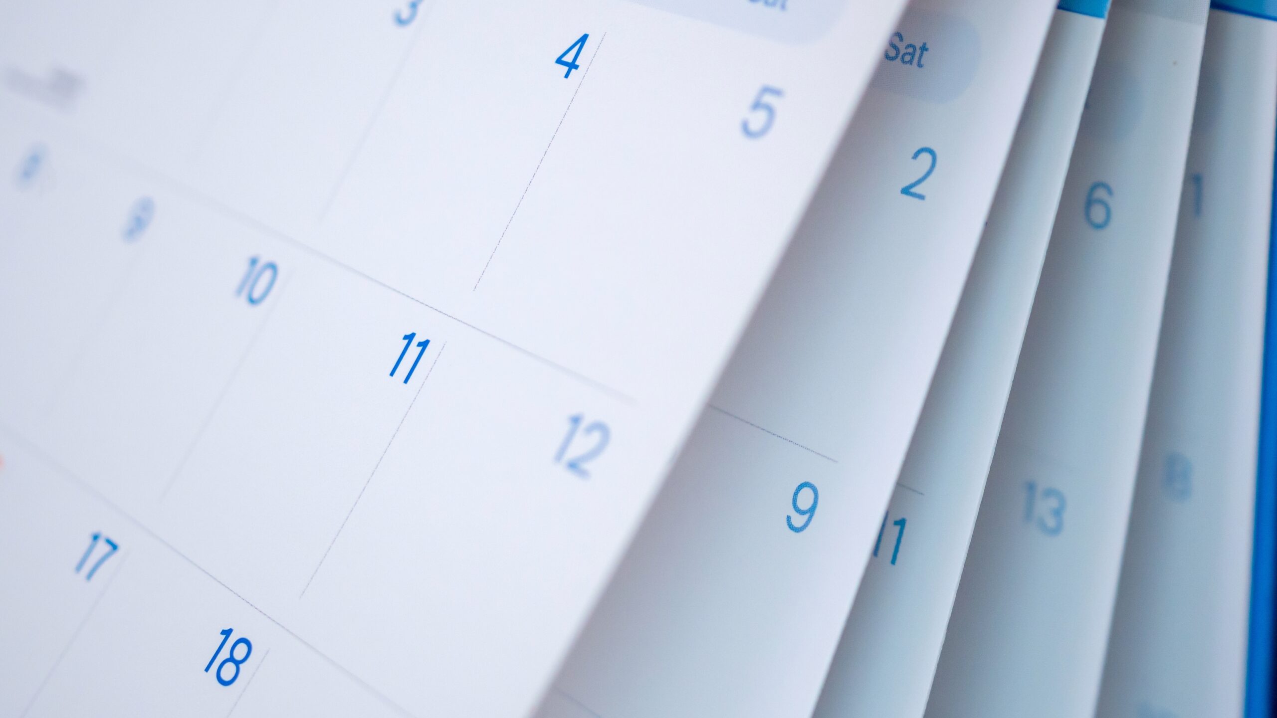 Close-up of monthly calendar pages with dates visible as pages flip.