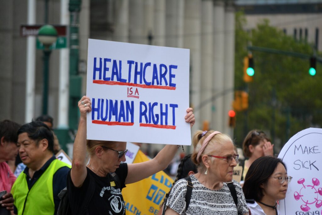 Healthcare advocates participate in a public demonstration holding the "Healthcare is a Human Right" banner.