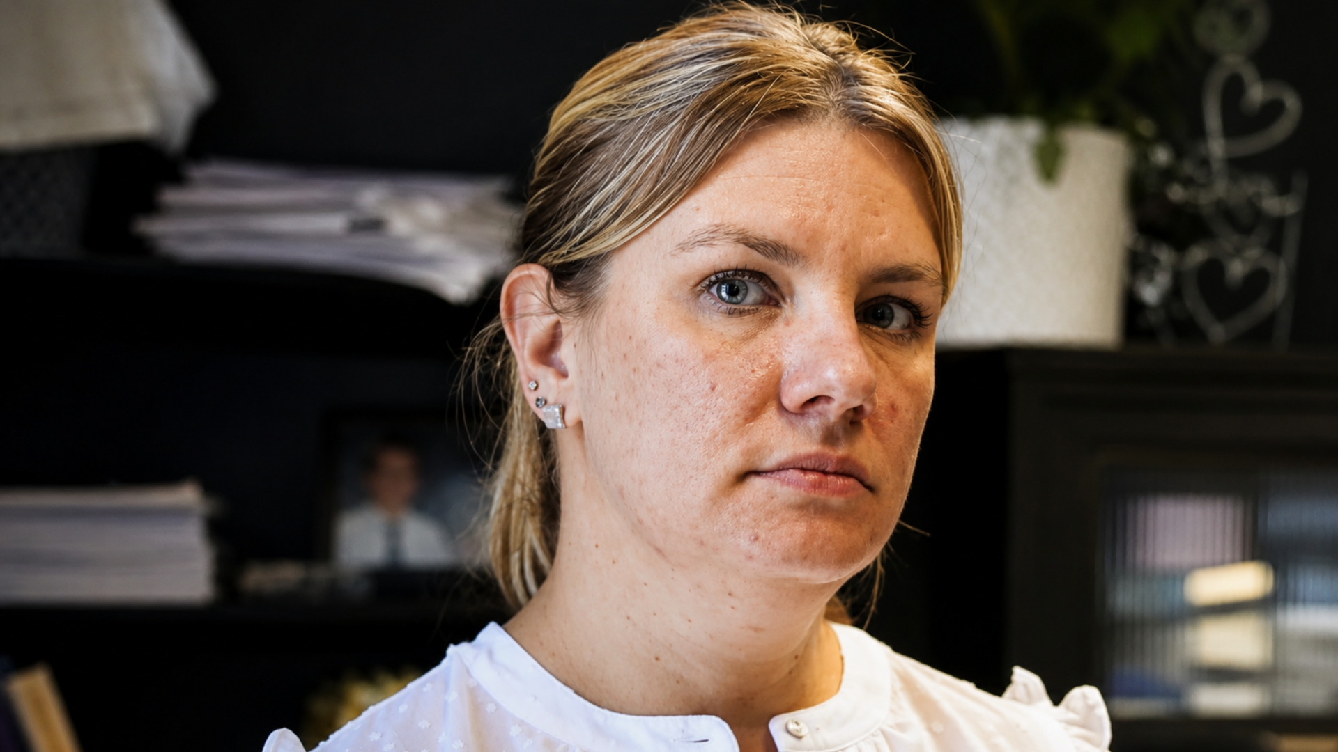 Woman looking toward the camera in a home office.
