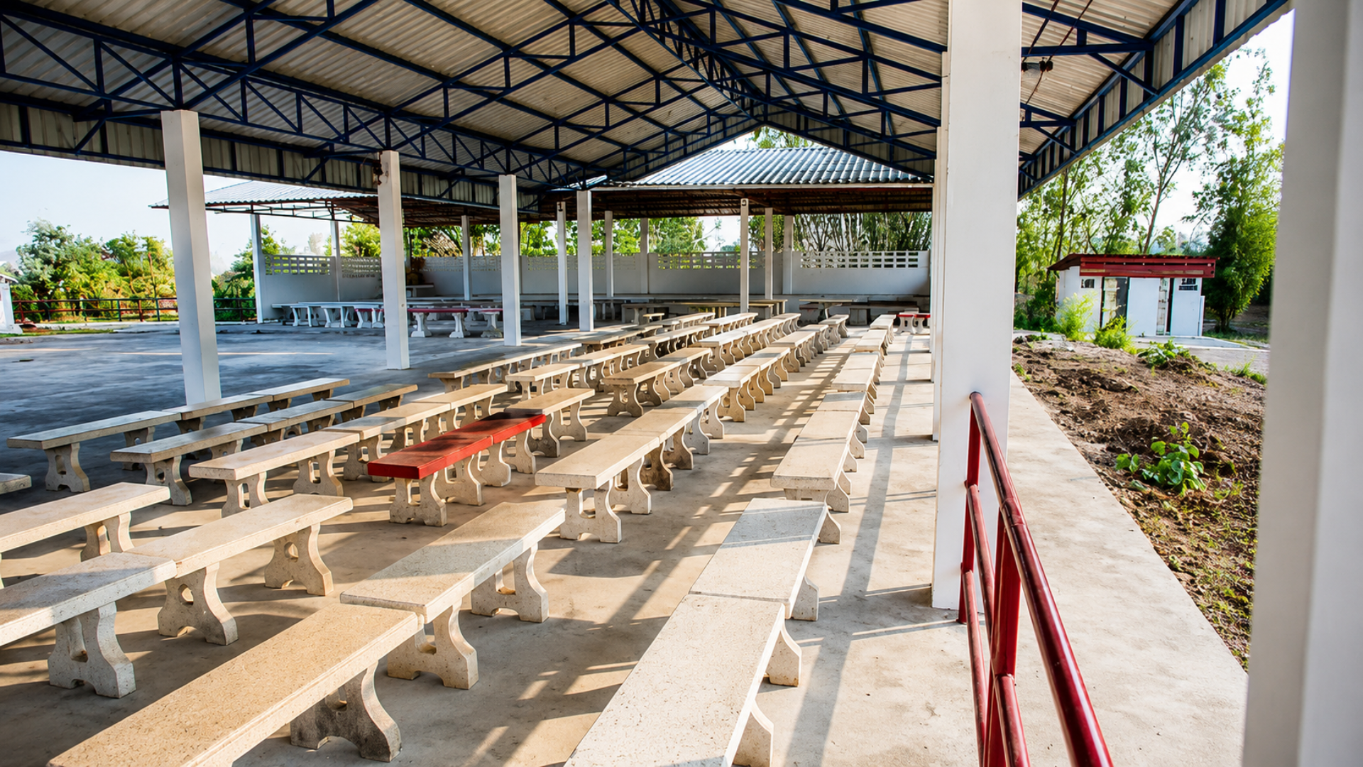 Empty benches under a covered outdoor pavilion.
