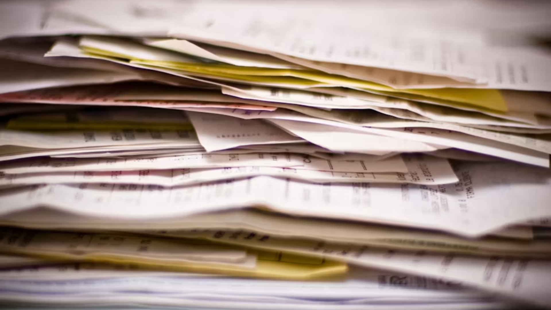 Stack of medical bills and paperwork piled on a desk.