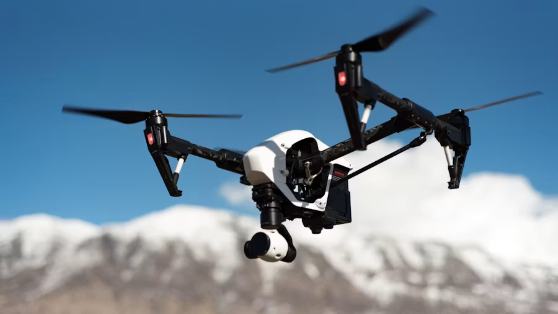 Drone flying over snow-covered mountains.