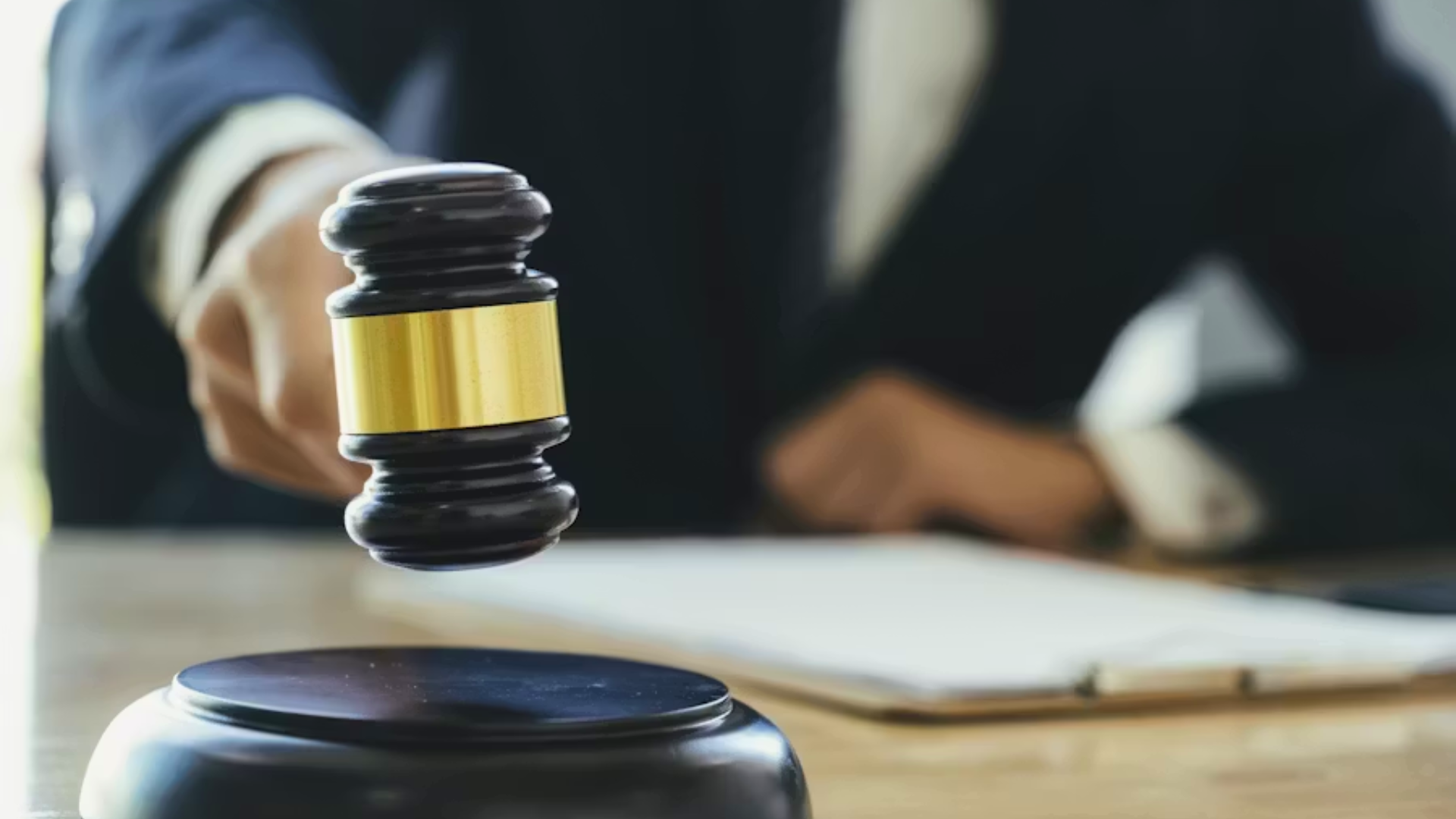 Judge striking a gavel during a legal proceeding.