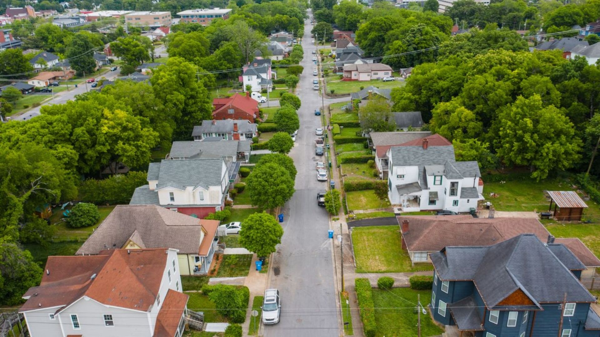 Aerial view of suburban neighborhood with tree lined streets.