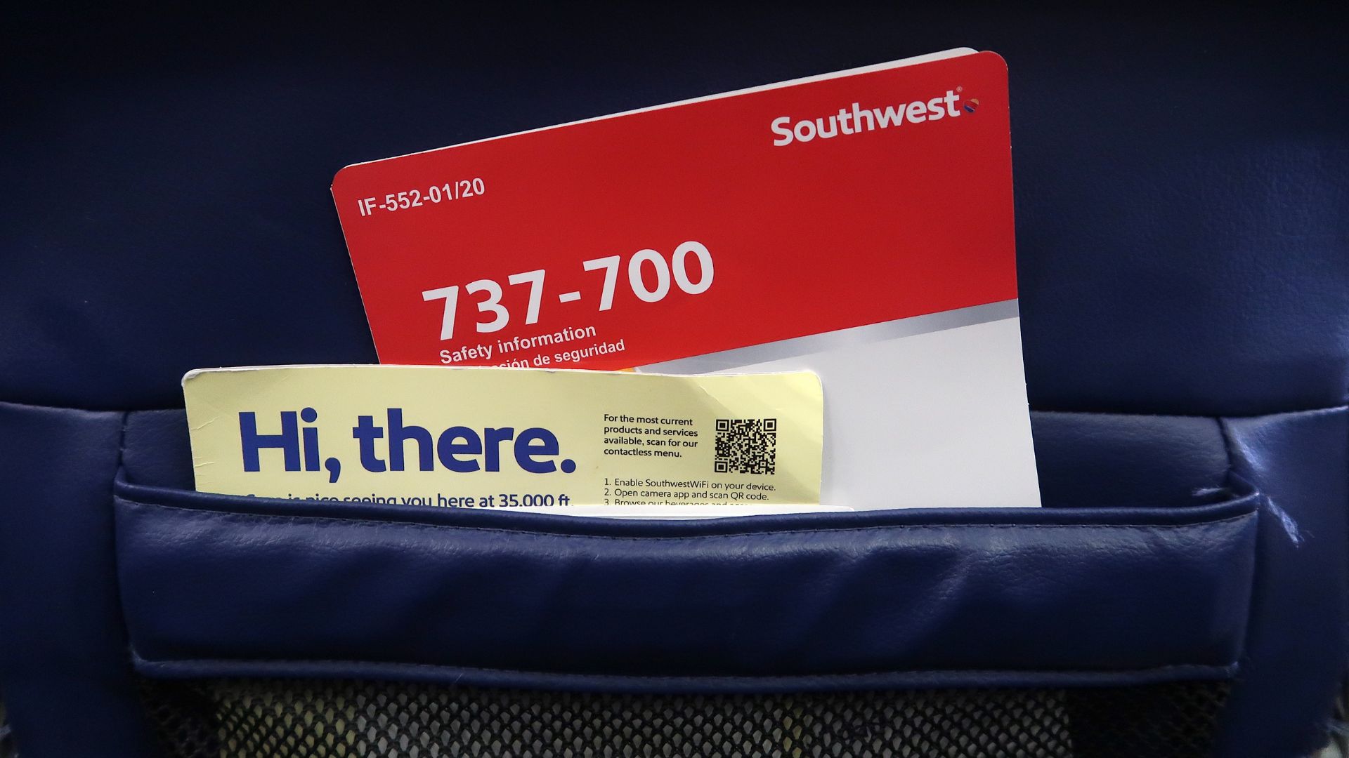 Southwest Airlines 737-700 safety information card and in-flight menu card tucked into a blue leather seat pocket.