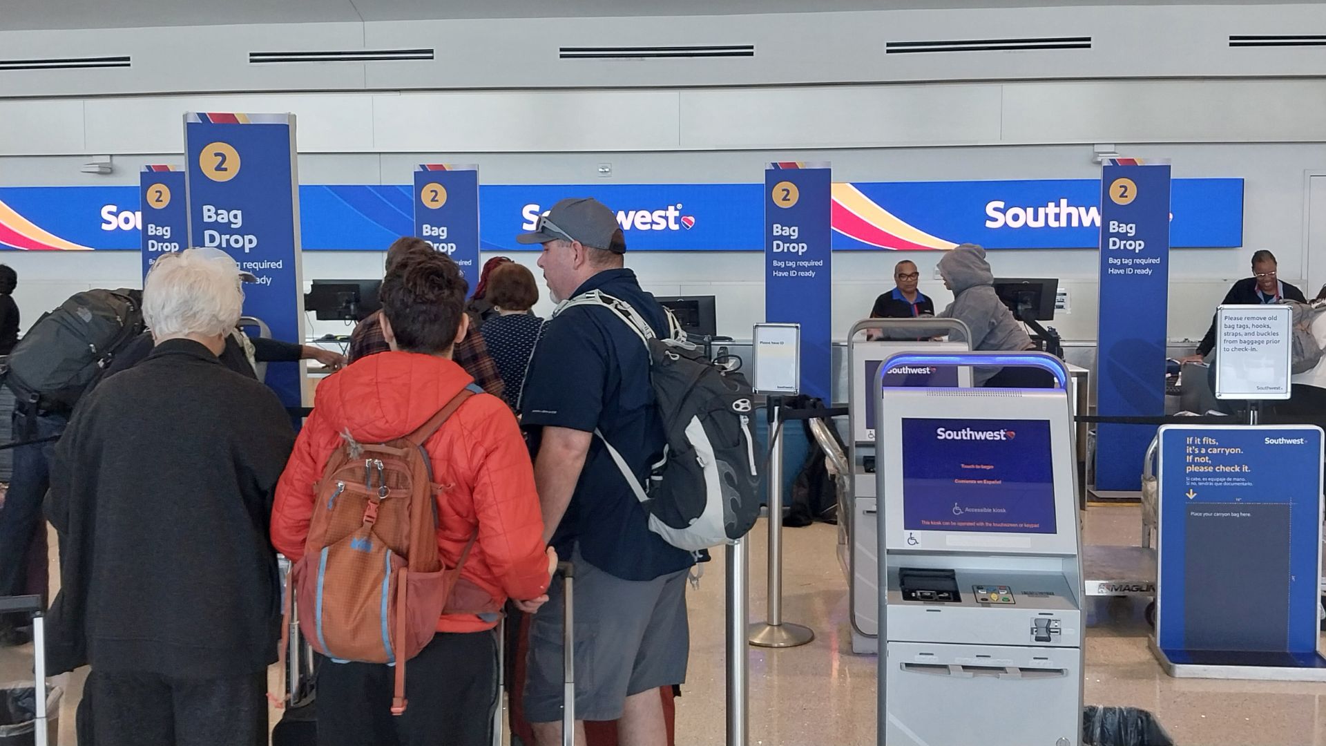 People with their luggage and backpacks in line at the Southwest Airlines ticket counter.