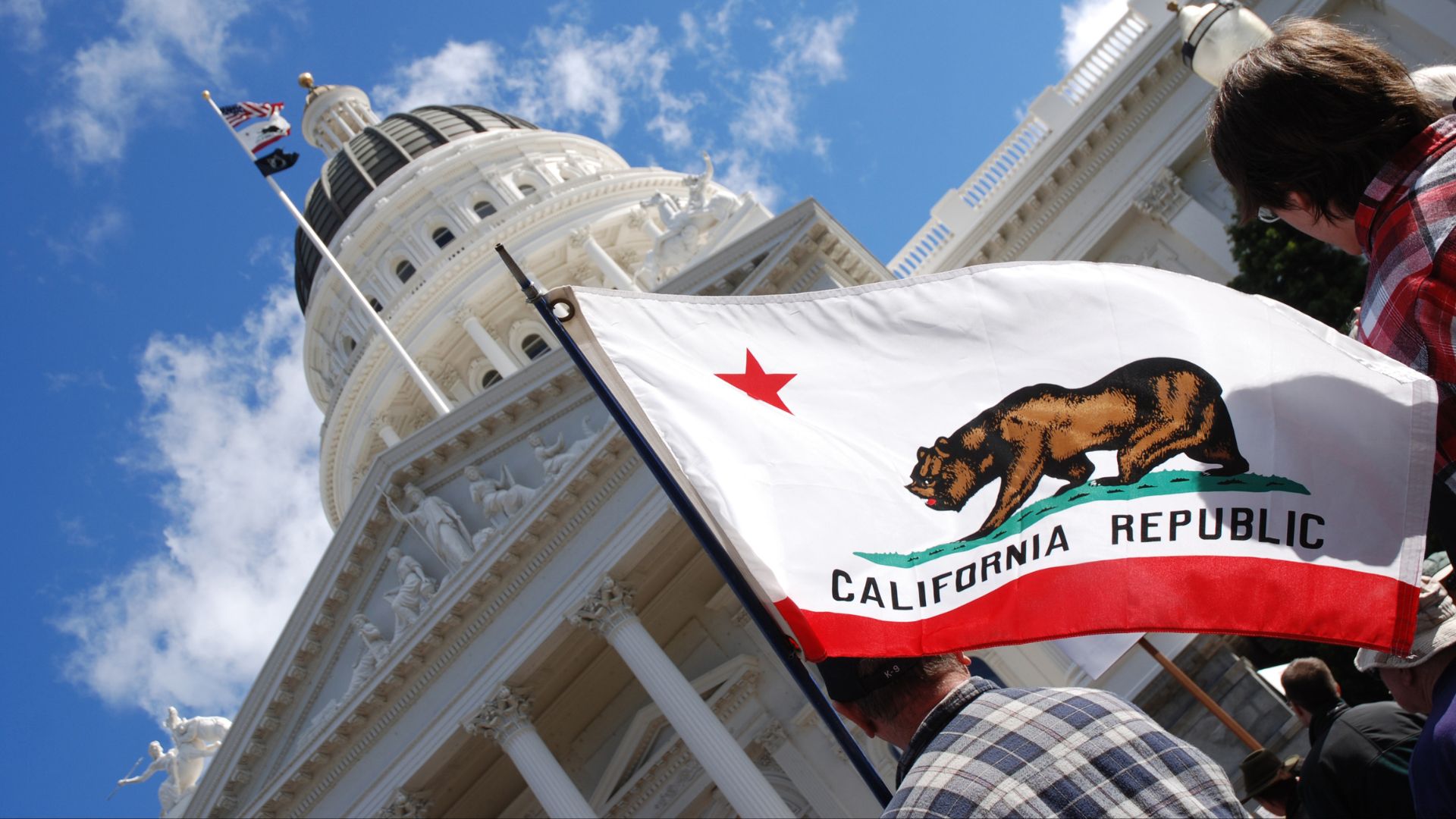 California Republic flag held in front of state capitol building in Sacramento.