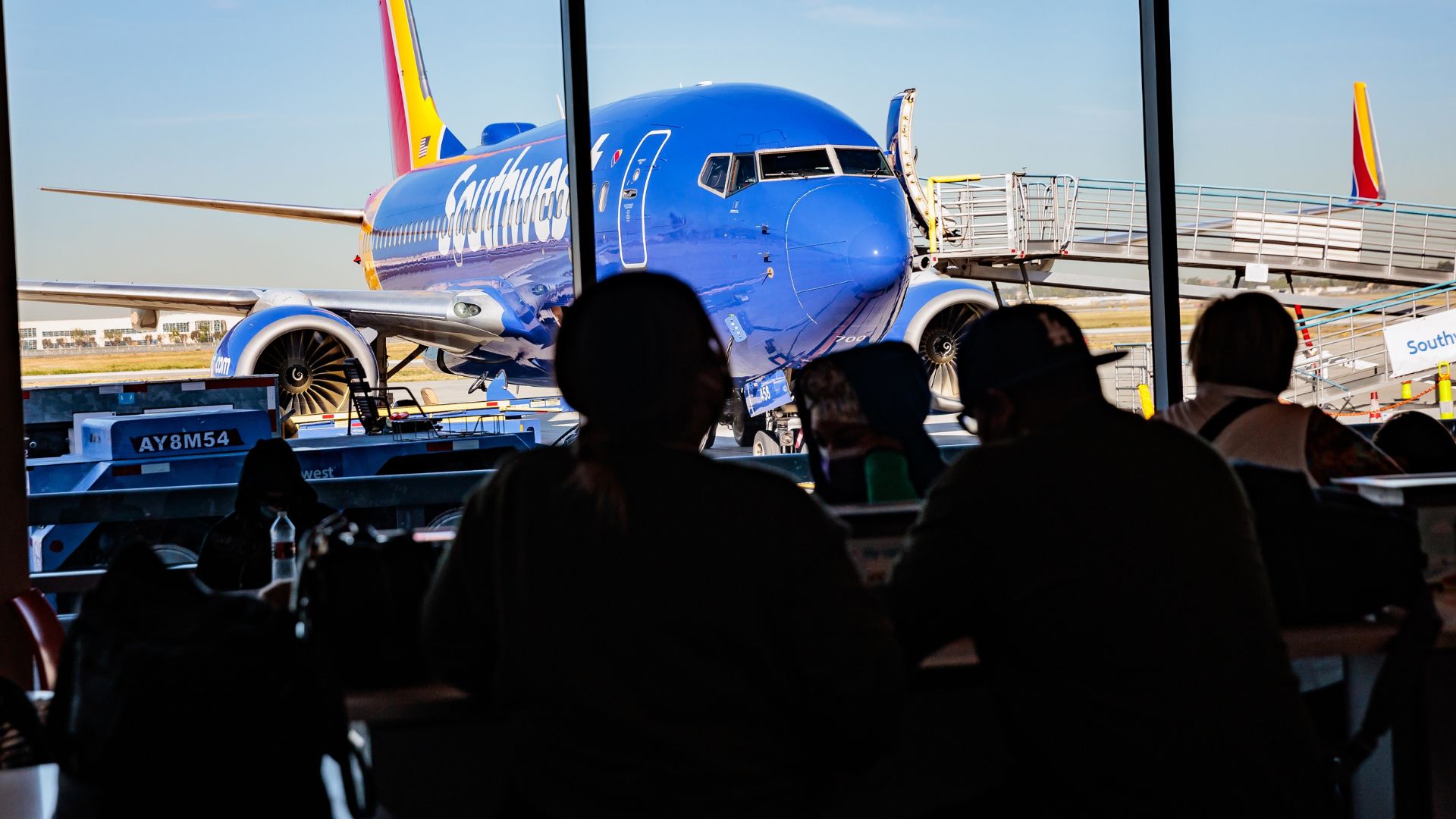 Passengers wait for their flights near the Southwest Airlines gate inside of the Long Beach Airport concourse.