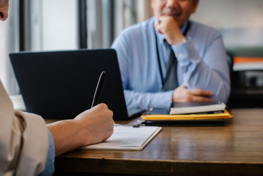 Person meeting with a caseworker while completing paperwork at an office.
