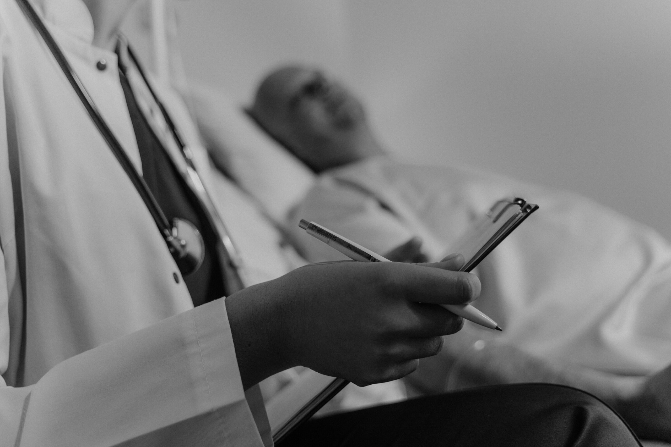 Doctor reviews notes during a consultation with a patient, reflecting ongoing care and emerging treatment options for pancreatic cancer.