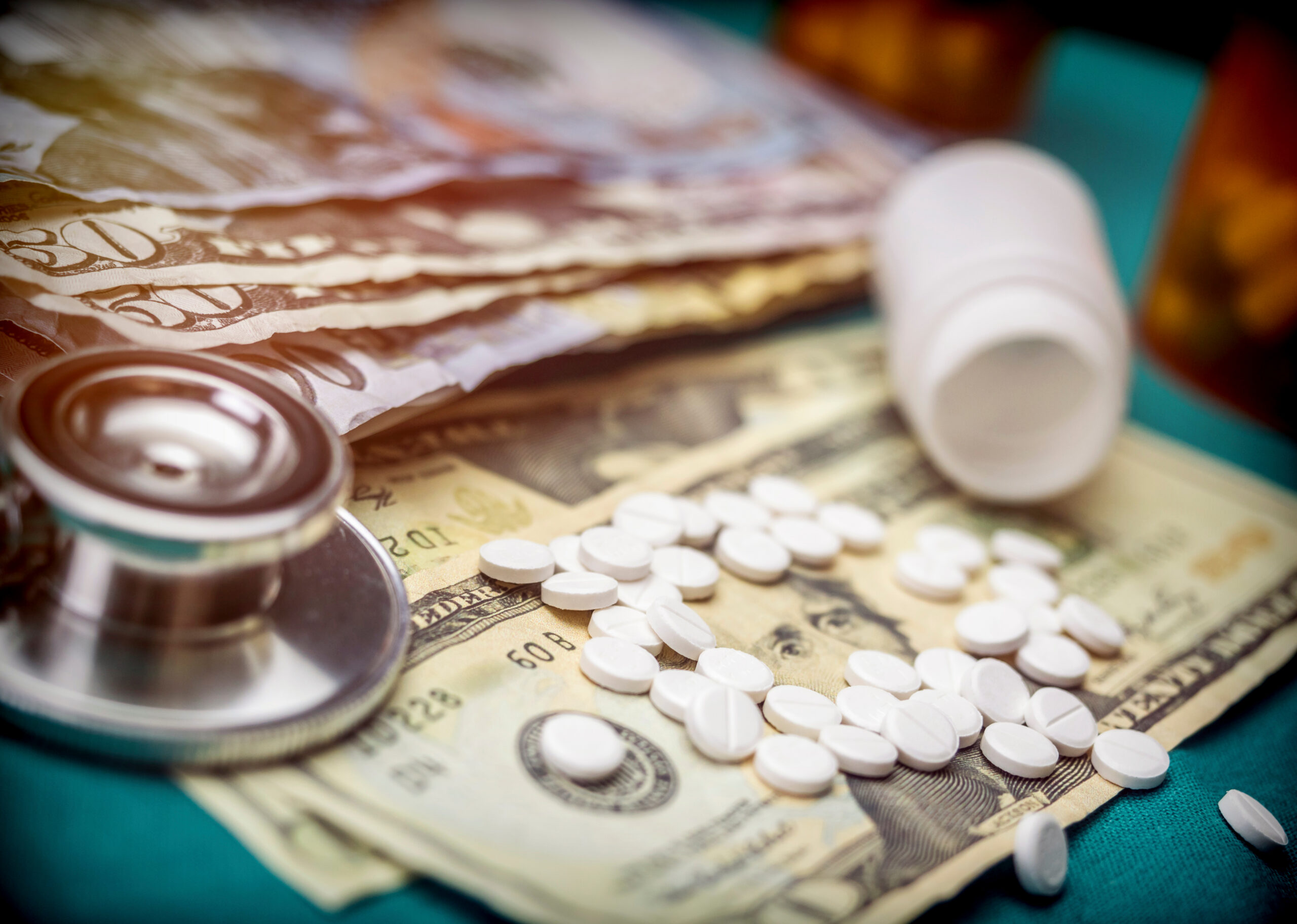 Prescription pills and cash highlight the growing financial burden of healthcare and medication costs.