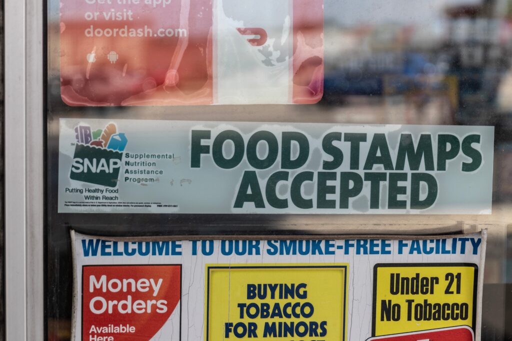 SNAP food stamps accepted sign displayed on the window of a convenience store.