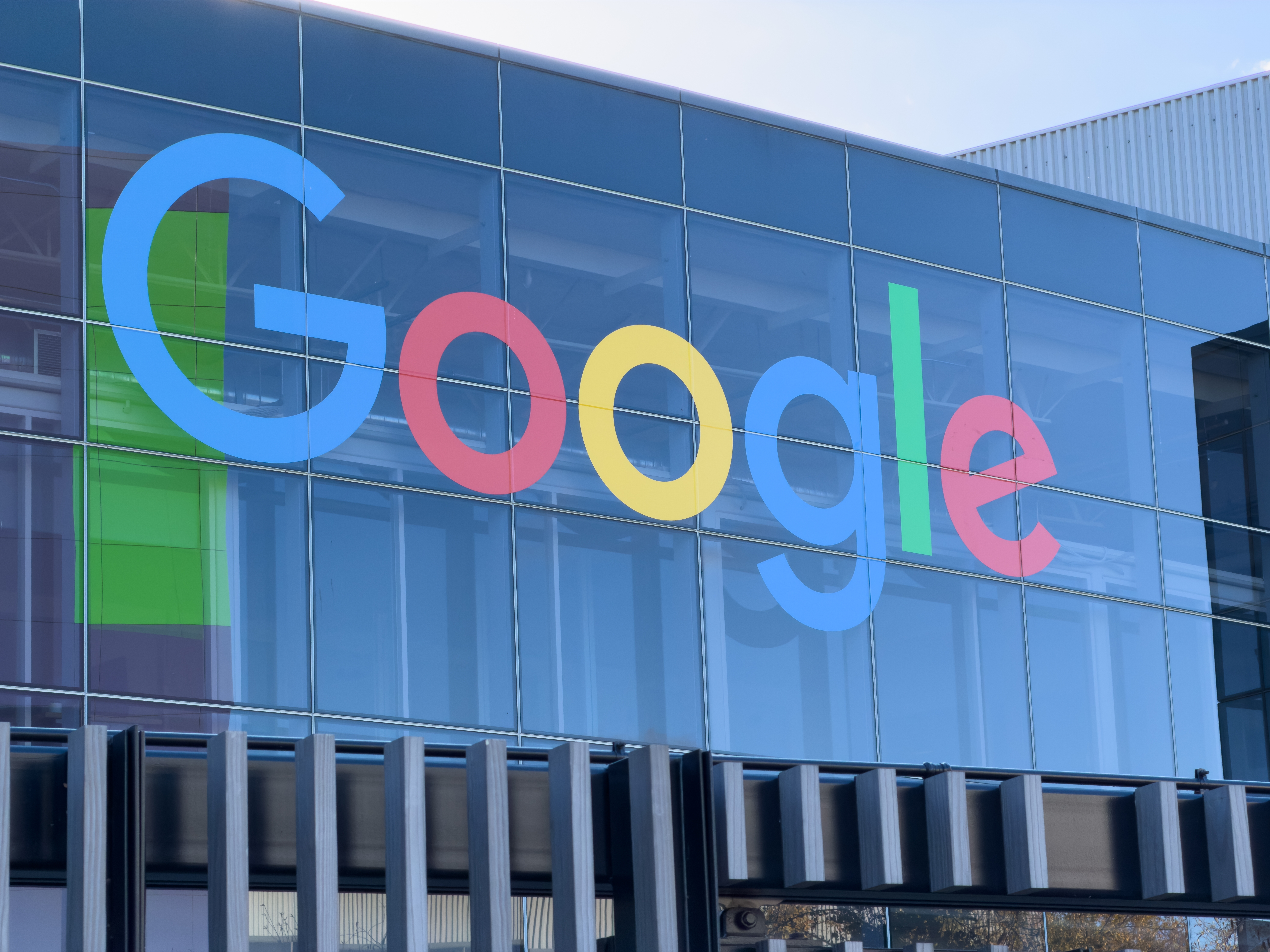 Google logo displayed on the exterior glass facade of a company office building.