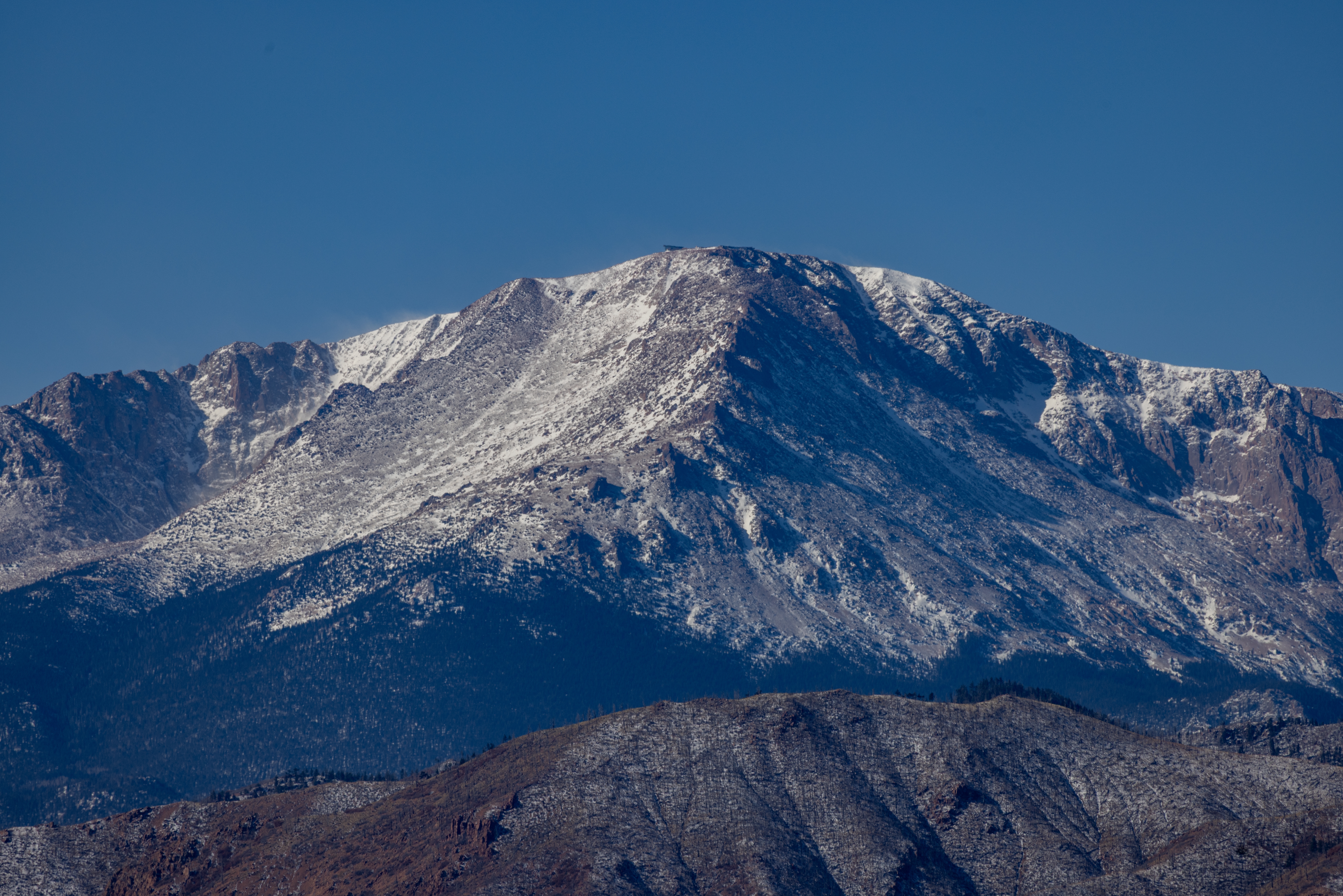 Low snowpack covers portions of the Front Range mountains near Colorado Springs during an unusually dry winter season.