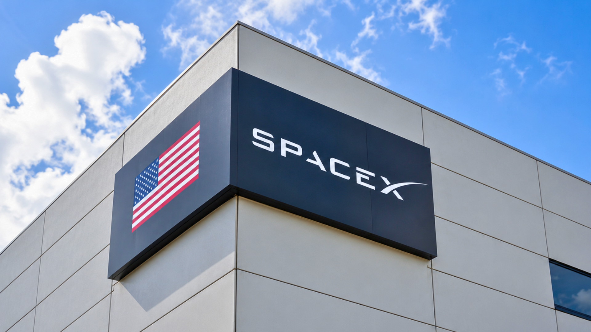 SpaceX sign with an American flag on the side of a building.