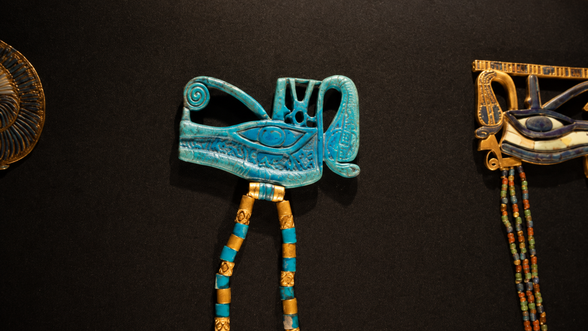 Ancient Egyptian Eye of Horus amulets displayed in a museum exhibit.