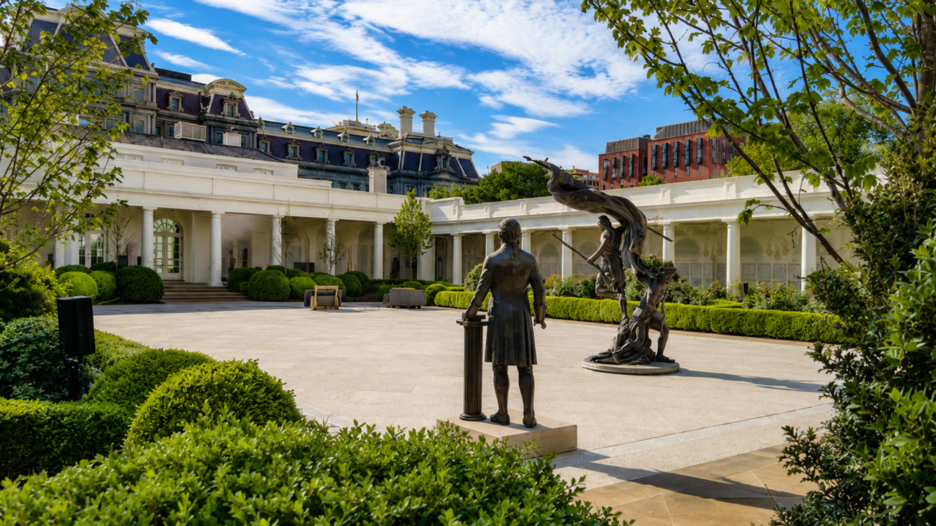 Statues displayed in a landscaped courtyard beside the White House, with colonnades and manicured hedges.